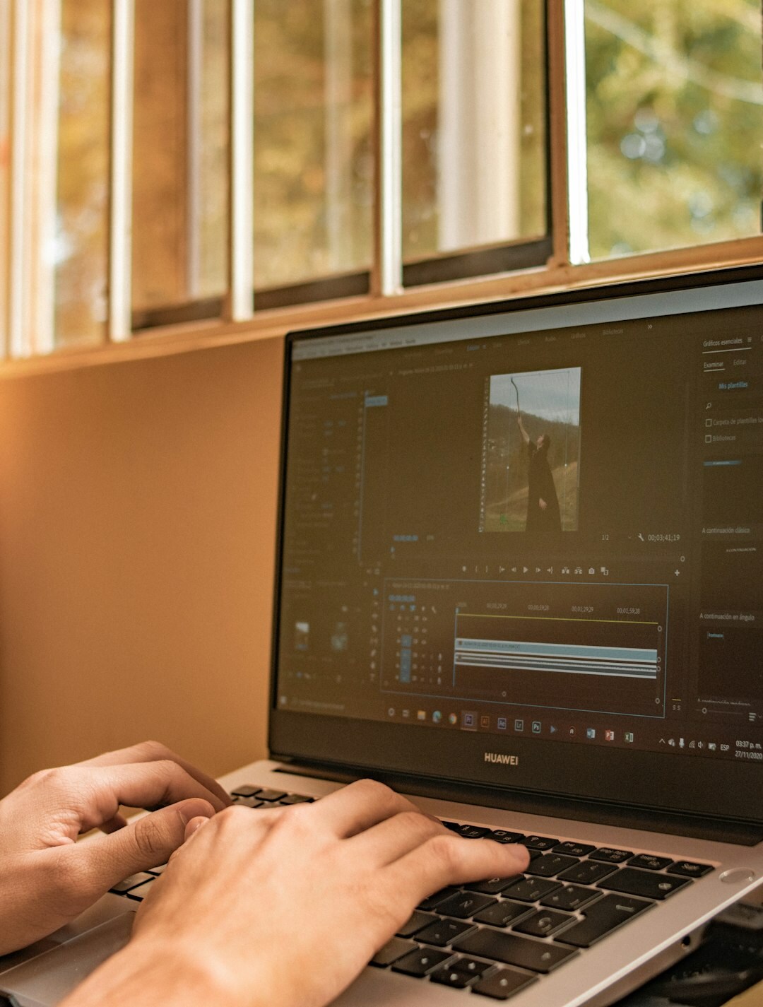 Close-up of hands typing on a laptop showing marketing charts
